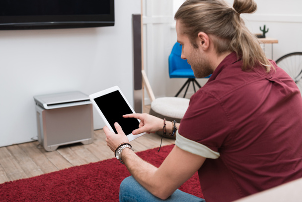 Mann sitzt auf Sofa und nutzt digitales Tablet   - Foto, Bild