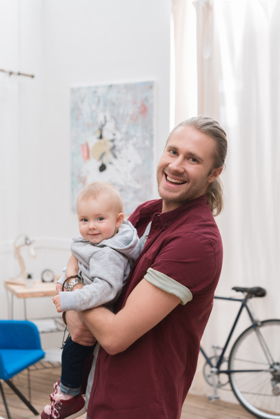 smiling father holding his little son at home - Foto, Imagen