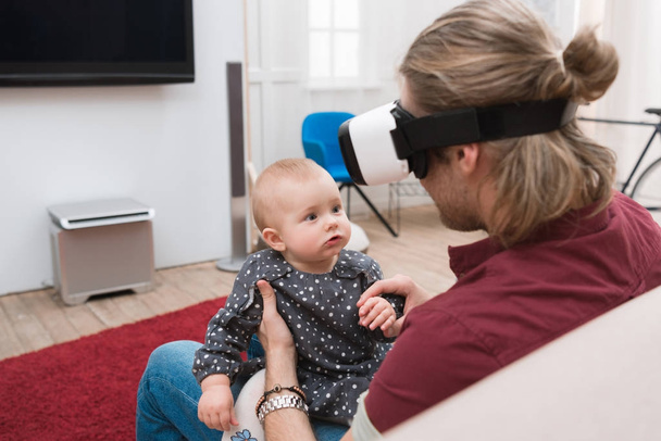 father sitting with his little daughter and using Virtual reality headset - 写真・画像