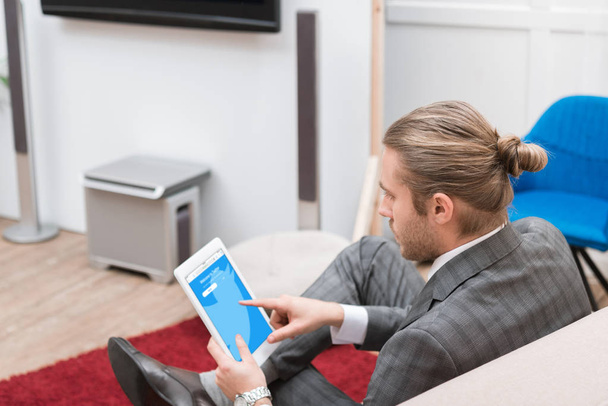 businessman using digital tablet with twitter website at home - Foto, Bild