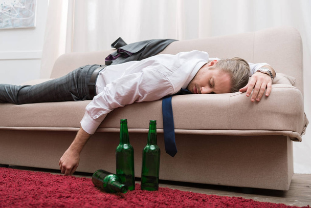 Pijany mężczyzna śpi na kanapie w salonie - Zdjęcie, obraz