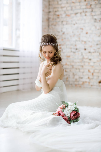Brunette bride in fashion white wedding dress with makeup - Foto, afbeelding
