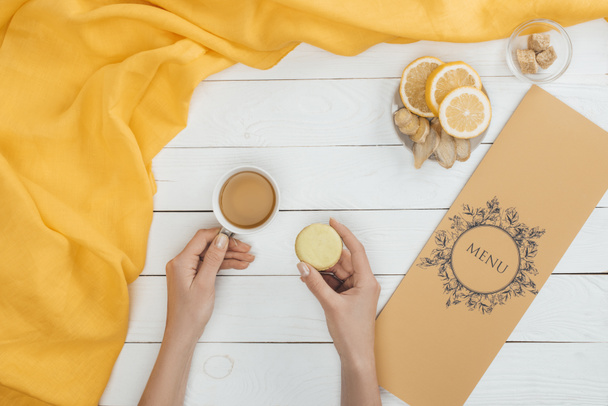 cup of tea and macaron in hands - Foto, Imagen