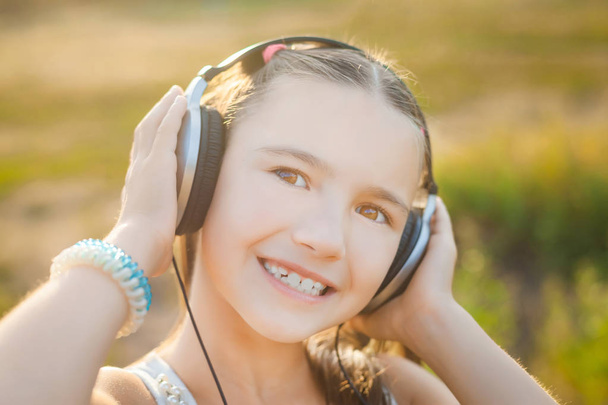 child listening music with headphones and smiling - Photo, image