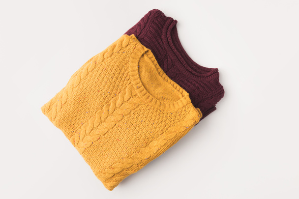 knitted burgundy and yellow sweaters - 写真・画像