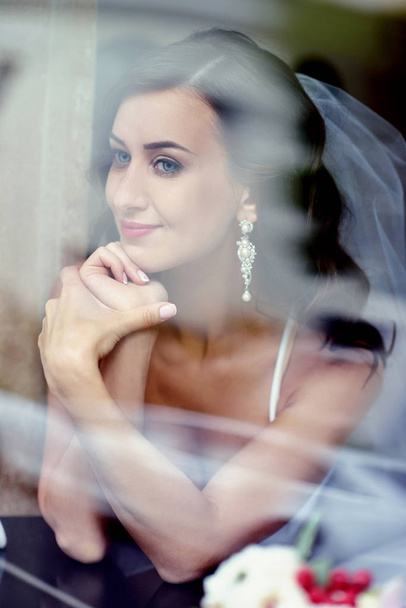 Beauty bride in bridal gown with lace veil indoors - Photo, Image