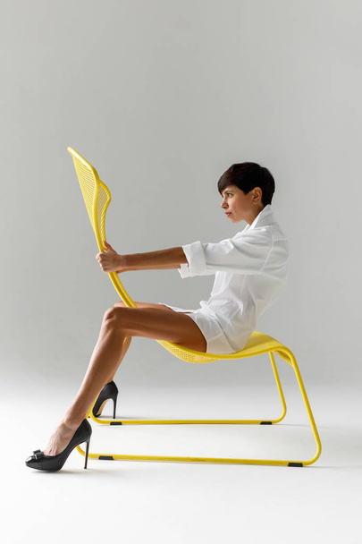 Trendy provocative model on modern chair - Φωτογραφία, εικόνα