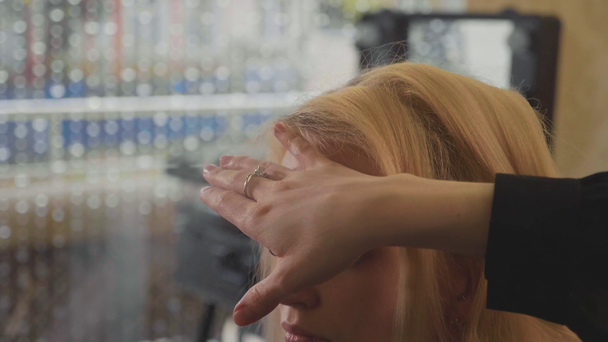 Genç kadın saç yapıyor ve saç spreyi kullanarak profesyonel stilist - Video, Çekim