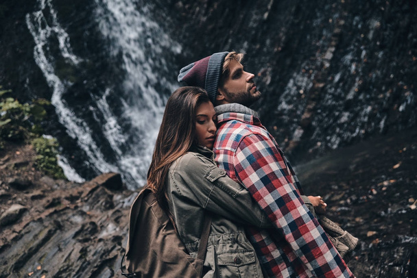 couple in love embracing near waterfall - Foto, Bild