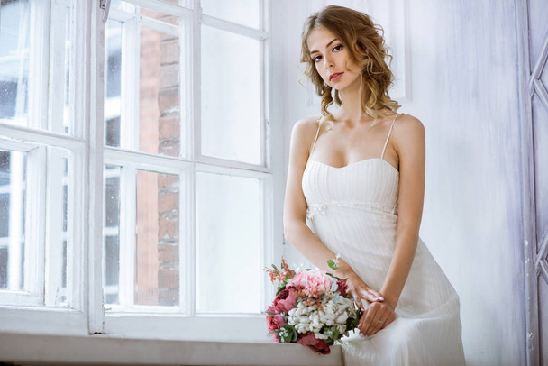 Brunette bride in fashion white wedding dress with makeup - Fotó, kép