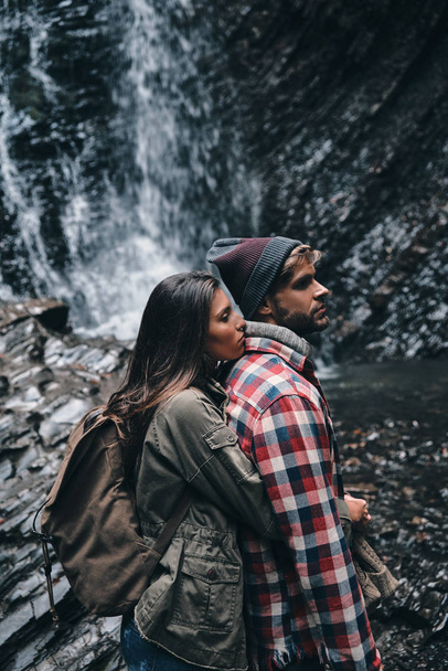 couple in love embracing near waterfall - Foto, afbeelding