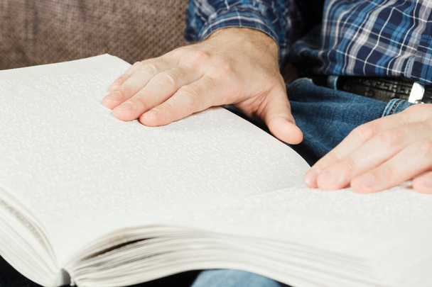 Ο τυφλός άνθρωπος διαβάζοντας ένα βιβλίο γραμμένο σε γραφή Braille. Αγγίξτε το  - Φωτογραφία, εικόνα
