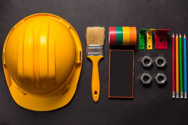 Construction tools and smart phone on black background - Foto, imagen