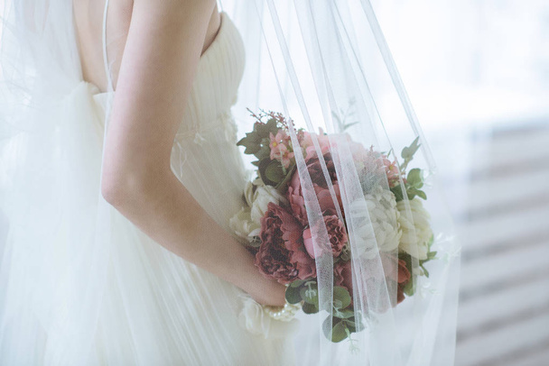 Beautiful bride is holding a wedding colorful bouquet - Foto, Bild