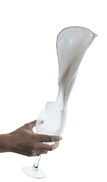 hand met glas met splash melk - Foto, afbeelding