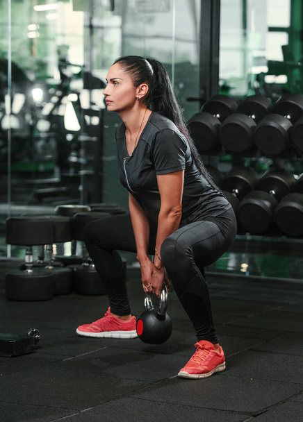 Fitness woman training by kettlebell. - Photo, image