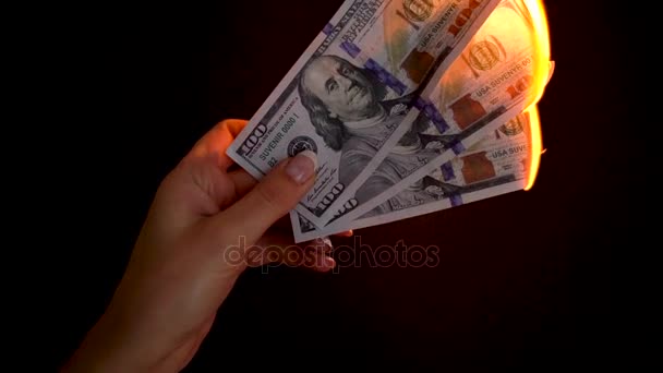 Καύση δολάρια σε ένα κοντινό πλάνο χέρι πάνω σε μαύρο φόντο. Αργή κίνηση - Πλάνα, βίντεο