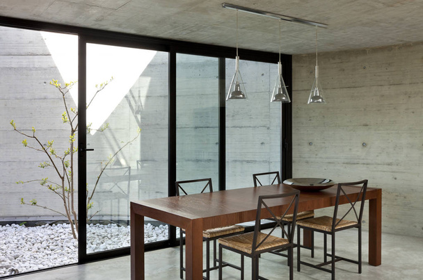 beautiful modern house in cement, interior, wooden dining table - Φωτογραφία, εικόνα