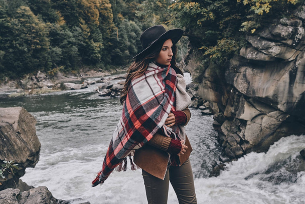 woman covered with blanket standing at river - Foto, Imagen