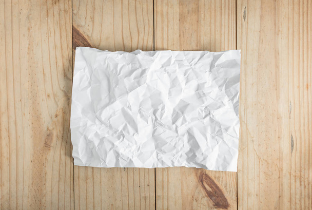 white crumpled paper on wooden background - Фото, изображение