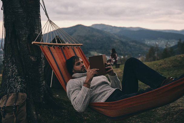 man reading book in hammock - Photo, image