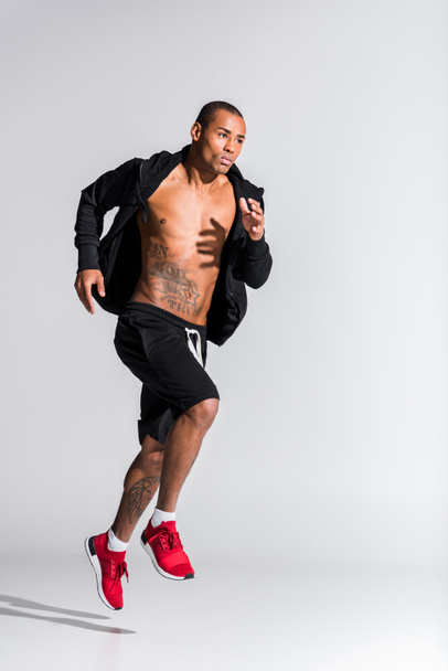 guapo joven afroamericano deportista corriendo en gris
  - Foto, Imagen