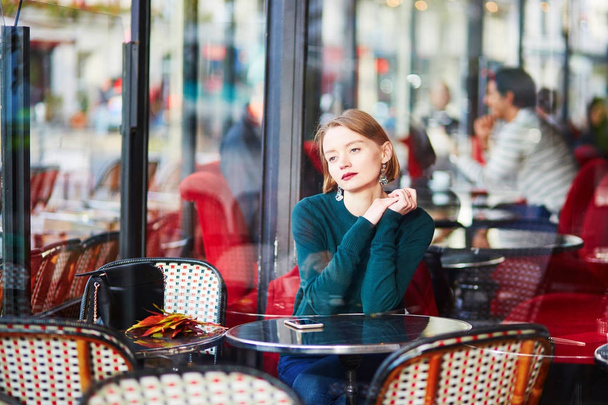 Young elegant woman drinking coffee in cafe in Paris, France - Фото, зображення