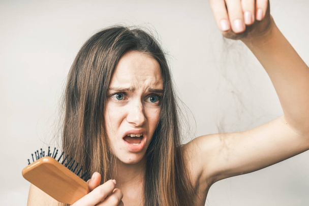 Woman with comb and lost hairs,looks upset and unhappy - Fotoğraf, Görsel