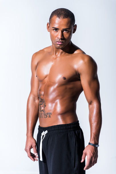 athletic sweaty shirtless african american sportsman looking at camera isolated on grey - Photo, Image