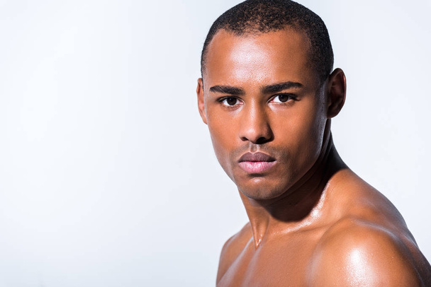 close-up portrait of young shirtless african american man looking at camera isolated on grey - Valokuva, kuva