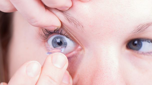 Close up of inserting a contact lens - Photo, Image