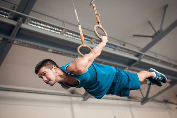 young athlete exercising with gymnastics rings; - Foto, Bild