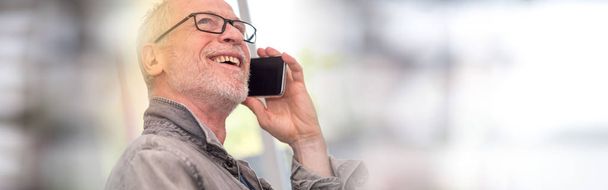 Πορτρέτο του χαμογελώντας ώριμος άνδρας μιλάει στο τηλέφωνο, ελαφριά επίδραση - Φωτογραφία, εικόνα