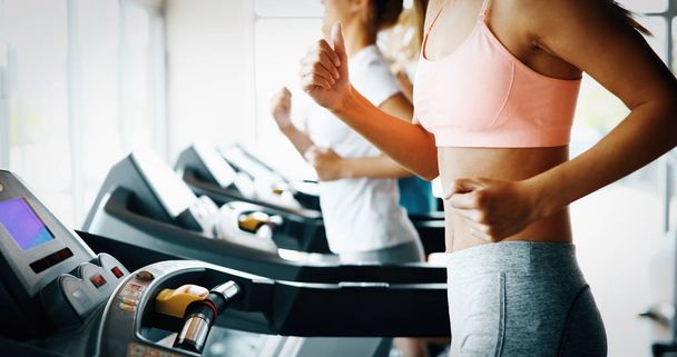 friends exercising on treadmill machine - Фото, изображение
