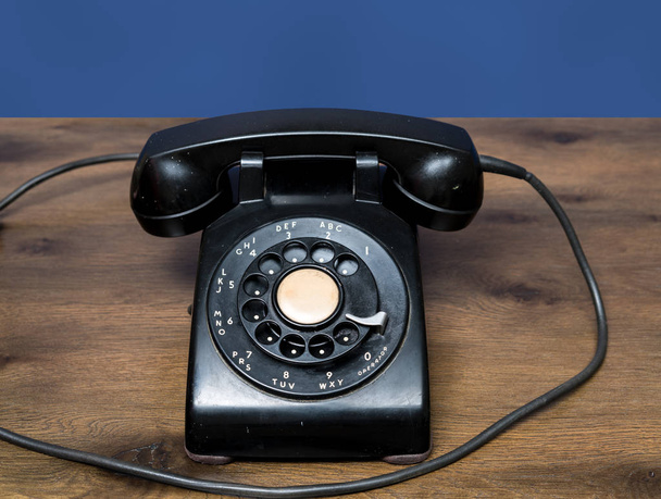 Antiguo teléfono de línea giratoria en escritorio de madera
 - Foto, imagen