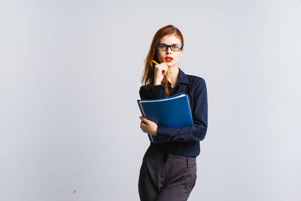 Girl secretary in glasses holds a file in her hands and listens carefully to someone - 写真・画像