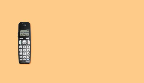 Старая беспроводная кнопка телефона на оранжевом фоне
 - Фото, изображение