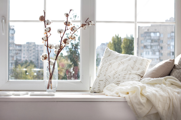 cuscini e un plaid in maglia sul davanzale della finestra
.  - Foto, immagini