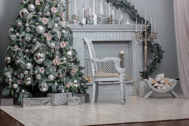 Joulukoristeet - huone, jossa kaunis tuoli, takka ja joulukuusi
 - Valokuva, kuva