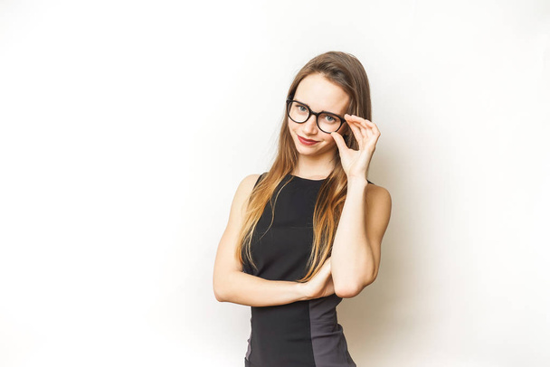Happy successful young woman in glasses,in a black dress, smiling and looking at the camera - Fotó, kép