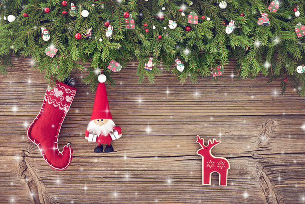 Christmas background. Christmas decoration with Santa and red Christmas sock on wooden background with snow. Copy space - Photo, Image