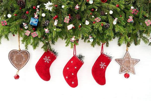Fondo de Navidad. Árbol de abeto de Navidad con calcetines de Navidad sobre fondo de madera blanca
.  - Foto, Imagen