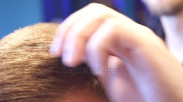 Чоловік-перукар робить розчісування волосся своєму чоловічому клієнту в перукарні. Процес укладання волосся. Повільний рух крупним планом
 - Кадри, відео