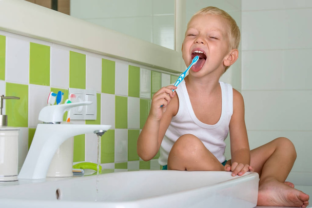 Szczotkowanie zębów w łazience mały chłopiec. Z początkiem nowego dnia - Zdjęcie, obraz