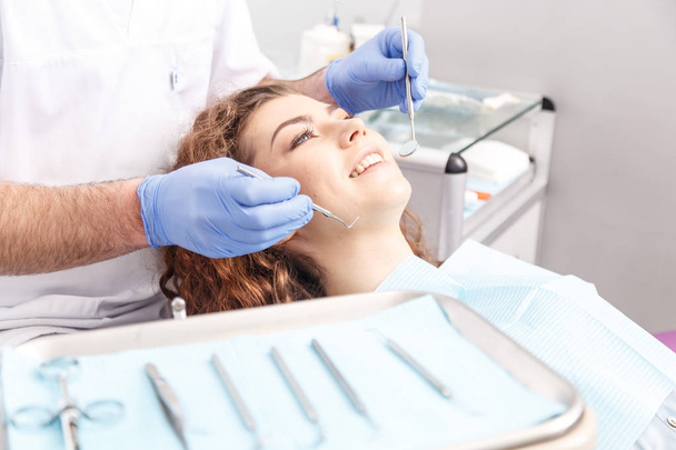 Стоматолог оглядає зуби пацієнта у стоматолога
 - Фото, зображення