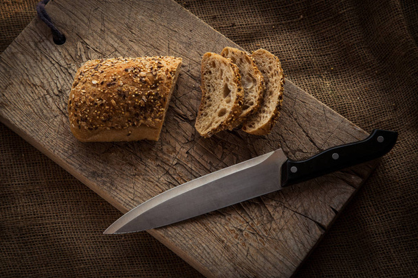 Wooden cutting board with sliced bread - Φωτογραφία, εικόνα
