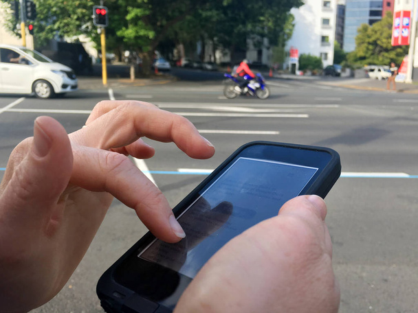 Доросла жінка вручає текстові повідомлення на міській вулиці
 - Фото, зображення