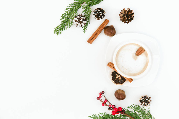 Christmas. Cup of coffee, larch branches, cinnamon sticks, over white background. Flat lay composition - Foto, afbeelding
