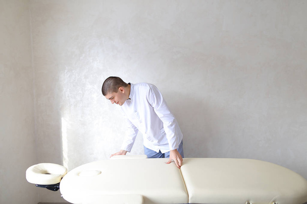 professionelle männliche Massagetherapeutin bereitet sich auf Patienten vor - Foto, Bild