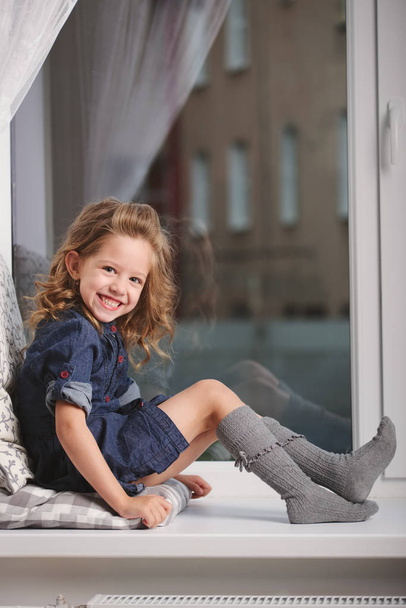 little girl on the windowsill at home - Foto, immagini